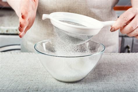 Proceso de colar glaseado de chocolate a través de un colador fino