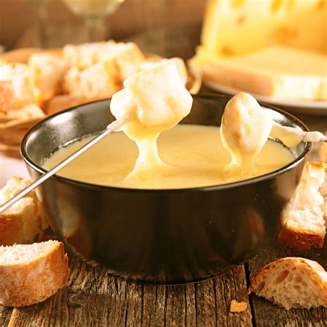 Foto de fondue de queso humeante con trozos de pan
