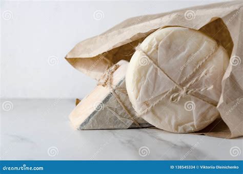 ilustracion de un queso fresco envuelto en papel encerado dentro de un recipiente en una despensa