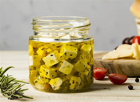 fotografía de trozos de queso sumergidos en aceite de oliva en un frasco de cristal