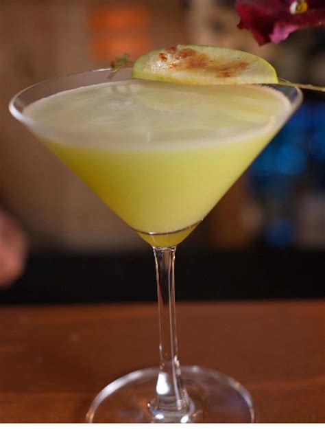 Appletini servido en una copa de Martini, adornado con una rodaja de manzana verde