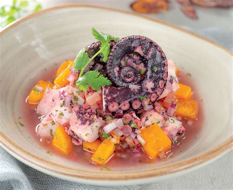 Ceviche de pulpo con leche de coco, choclo y aguacate, servido en un tazón