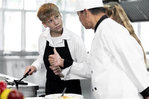 Estudiante de gastronomía practicando técnicas culinarias en un laboratorio bien equipado
