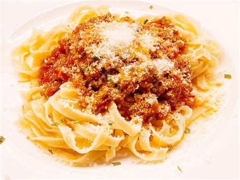 Plato de corbatitas con salsa boloñesa y queso parmesano