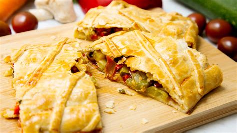 Empanadas vegetarianas variadas y coloridas en un plato de madera