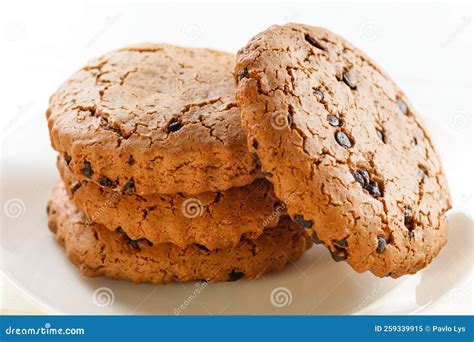 Pequeños dulces como M&Ms y trozos de chocolate ensartados en palillos sobre cupcakes.