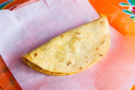 Ilustración de una quesadilla mexicana doblada, recién hecha en un puesto de mercado