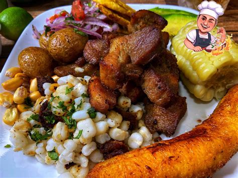 Plato de fritada ecuatoriana con acompañamientos como mote, papas, maduro frito y aguacate