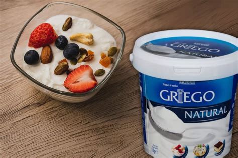 Fotografía de un cuenco de yogur griego o crema de leche junto a un plato de comida picante.