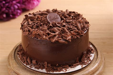 Foto de torta decorada con cintas y rulos de chocolate.