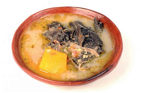 Plato humeante de caldo de librillo con leche, guarnecido con maduros y aguacate