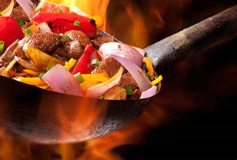 lomo saltado con cebolla y tomate en un wok