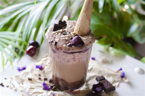Vaso de milkshake vegano con chocolate y cerezas, decorado