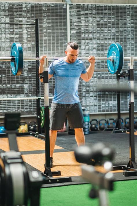 Un atleta en un gimnasio levantando pesas, mostrando músculos