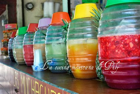Mercado tradicional mexicano con puestos de aguas frescas y bebidas en jarras