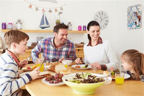 Mesa familiar con niños comiendo una comida saludable