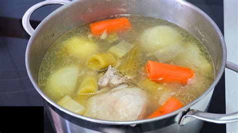 Foto de caldo de patas de pollo hirviendo lentamente en una olla