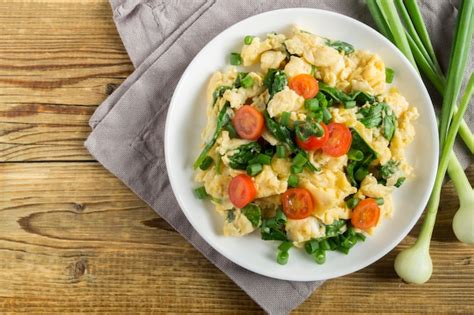 plato equilibrado con huevos revueltos, espinacas y tomates cherry como opción salada sin pan