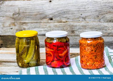 Tarros de cristal con escabeche de pimientos y otras verduras, listos para almacenar