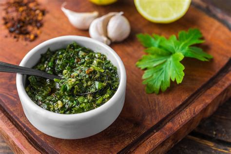 Foto de chimichurri recién preparado en un bol con hierbas frescas
