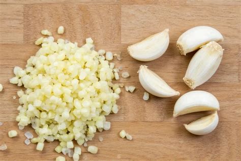 Perejil y ajo finamente picados en una tabla de cocina