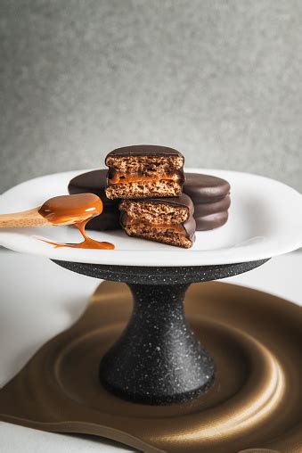 Alfajores artesanales variados apilados sobre un plato, con un toque de coco rallado y dulce de leche