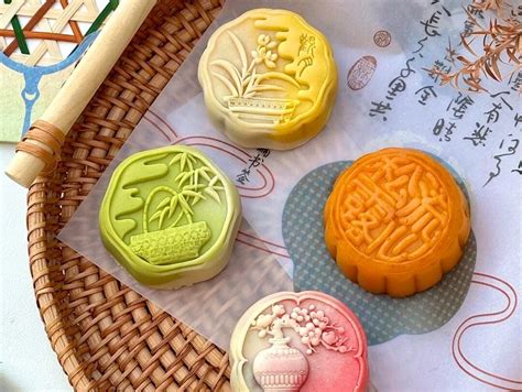 Fotografía profesional de un set de pasteles de luna veganos decorados con patrones tradicionales sobre una mesa de madera