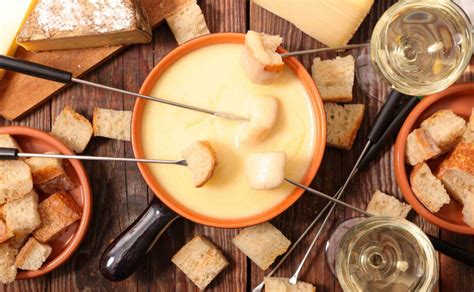 Fondue de queso con pan y vino blanco, destacando el uso del Gruyère