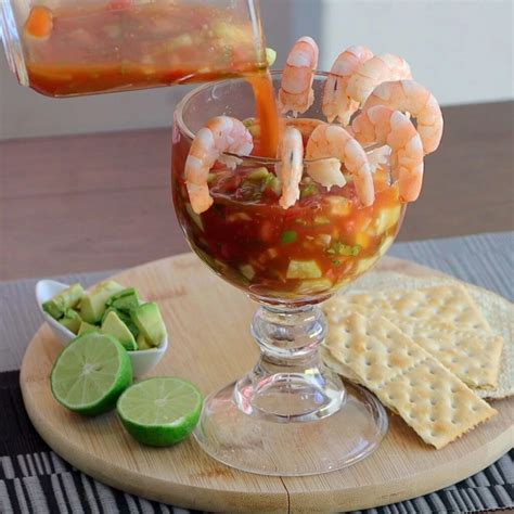 Plato de cóctel de camarones fresco servido en una copa clásica con aguacate y rodajas de lima