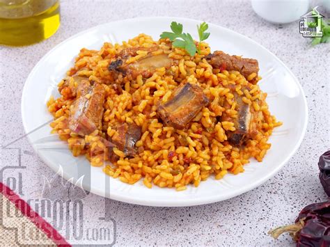 Plato de arroz con costillas de cerdo, vista superior, con hierbas aromáticas