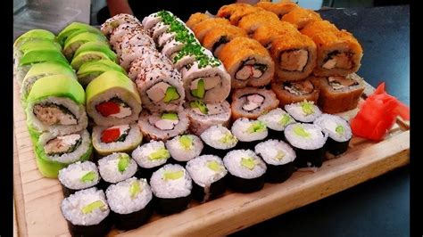 Variedad de cervezas japonesas frías junto a platos de sushi