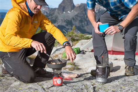 Cocina de campamento en la montaña: hornillo, cacerola y alimentos básicos