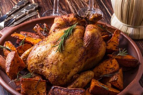 pollo asado entero en bandeja con hierbas