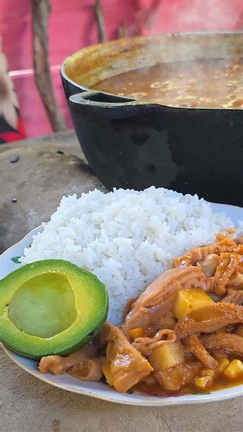 Mesa con mondongo guisado y acompañamientos como arroz blanco y aguacate