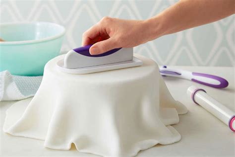 Proceso de alisado y cobertura de la torta con fondant o baño Wilton