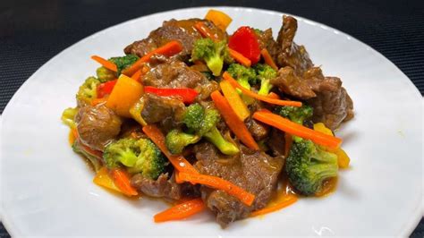 Plato de carne salteada al estilo chino con arroz, mostrando las verduras coloridas y la carne