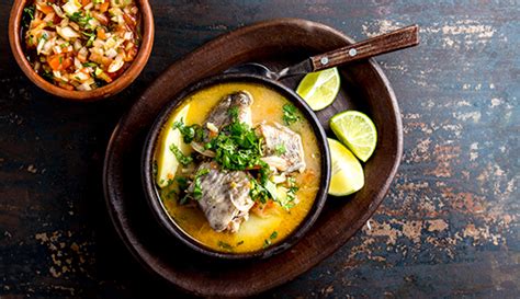 Caldillo de congrio servido en plato de greda con perejil fresco