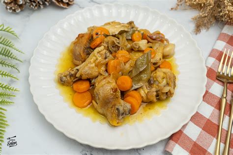 Plato de pollo en escabeche servido frío con guarnición y tarros de conserva.