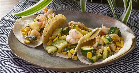 Variedad de platos con camarones, incluyendo tacos y cócteles