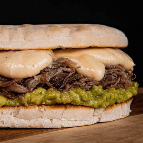 Foto de un sándwich de mechada chileno recién hecho con queso derretido