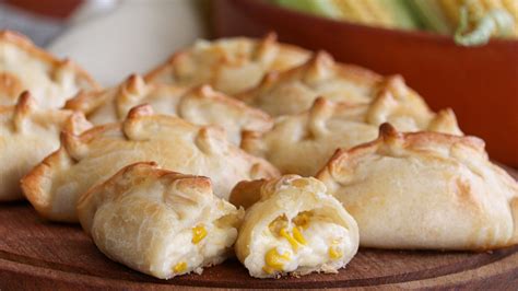 Empanadas y pastel de choclo, destacando la masa ligera y el relleno de pino.