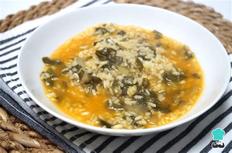 Plato de arroz caldoso con acelgas y costillas humeante servido en una cazuela de barro tradicional