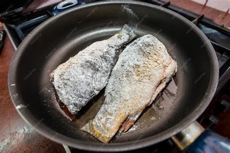 Pescado frito en sartén con aceite burbujeante
