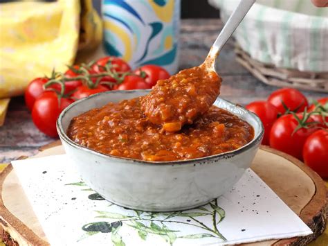Foto de una sartén con salsa boloñesa casera burbujeando con hierbas frescas.