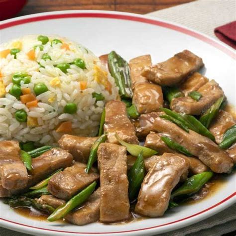 Plato de pulpa de cerdo dorada con verduras y arroz