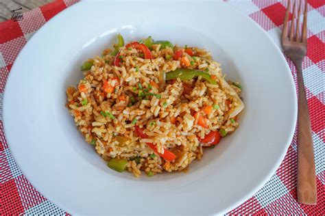 Fotografía de un wok profesional salteando arroz con vegetales y proteínas a fuego alto