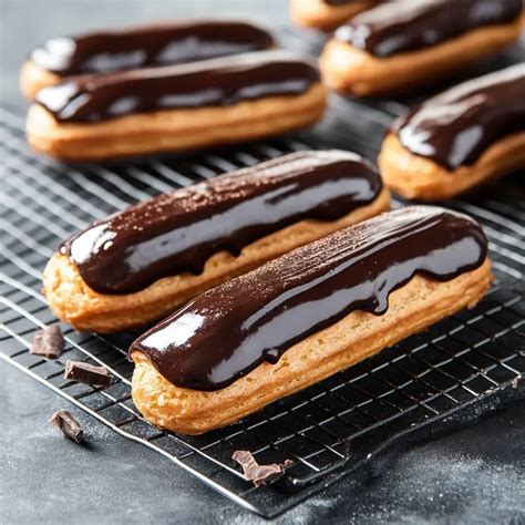 Bandeja con eclairs recién horneados y enfriándose en rejilla