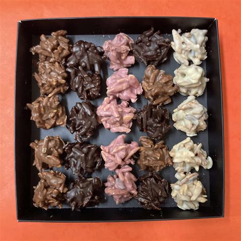 Imagen de primer plano de rocas de chocolate negro, con leche y blanco con frutos secos visibles
