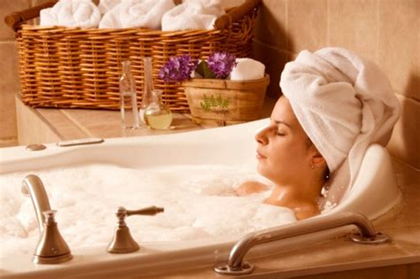 Persona disfrutando de un baño relajante con agua y un puñado de polvo de bicarbonato de sodio disolviéndose.