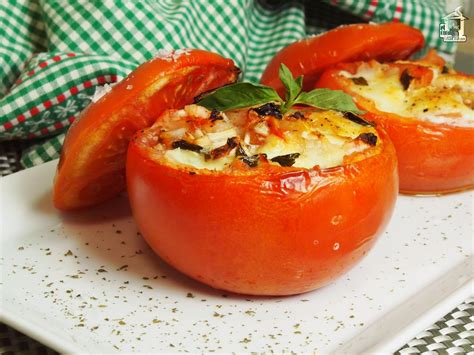 Tomates rellenos con queso y hierbas asándose en la parrilla